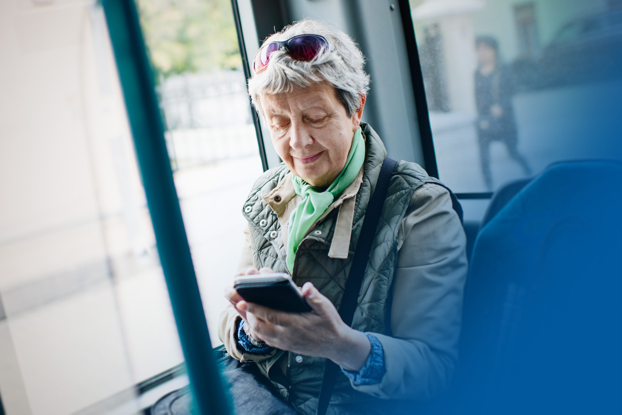 Senior woman using smartphone in the bus